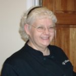 Chef Christy - white hair, black jacket